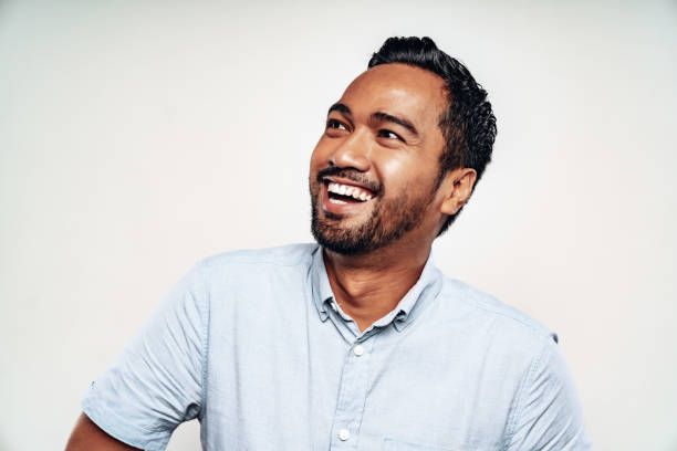 Happy Smiling Malaysian Man Studio Portrait Happy natural smiling Malaysian Man looking up with a toothy bright natural smile. White Background Studio Portrait Shot. Kuala Lumpur, Malaysia. mid adult men stock pictures, royalty-free photos & images