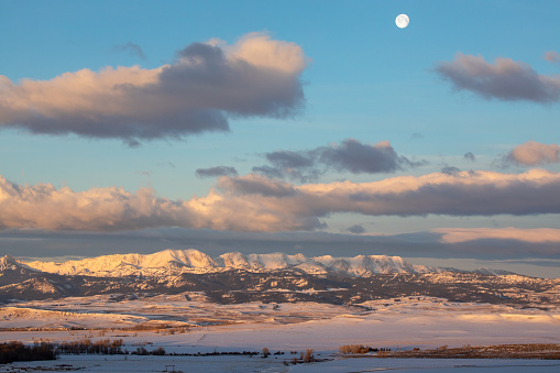 Landscape photo of the moon and skies over the Bridger Mountains.