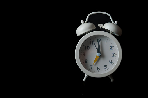 Old fashioned silver alarm clock on black background. 3d rendering illustration.