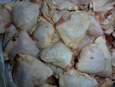 Texture of fresh chicken thighs. The chicken is unpacked from the box and defrosted. Chicken meat is placed in a box.