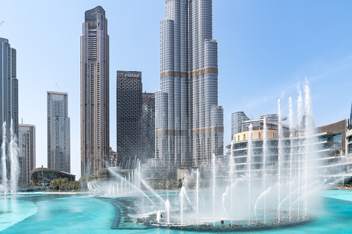 Dubai, United Arab Emirates - March 14, 2023:View of The Dubai Fountain and the big skyscraper Burj Khalifa during a sunny day in Dubai