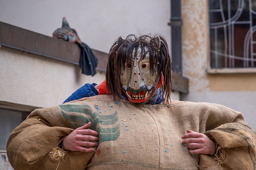 Evolène, Valais Canton, Switzerland -11 February, 2024: Reveller wearing wooden mask and carnival costume.