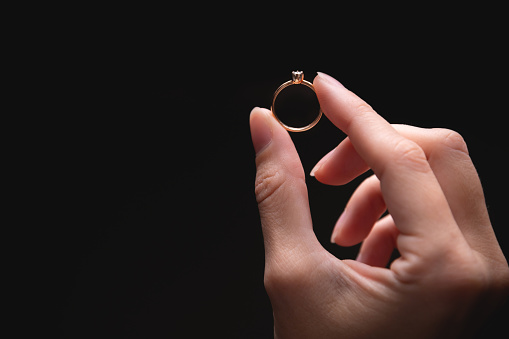 Millennial newlyweds hands showing wedding rings. Part of a series. Horizontal close-up indoors shot with copy space.