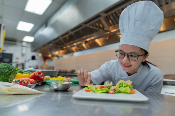 istock Asian female kitchen apprentice decorate the food 2017239340