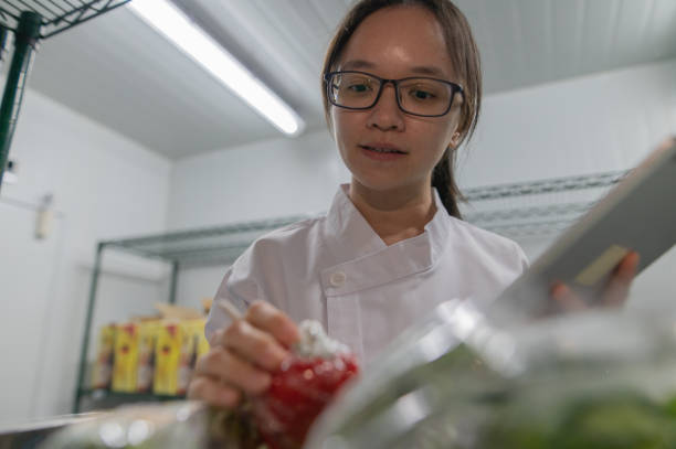 азиатская ученица-повар проверяет список ингредиентов - hygiene food chef trainee стоковые фото и изображения