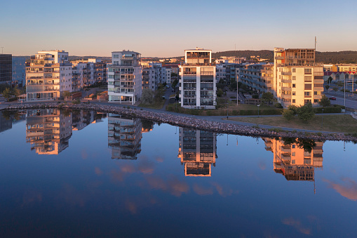 Modern apartment buildings reflected in the calm water at Munksjön in central Jönköping, Sweden.