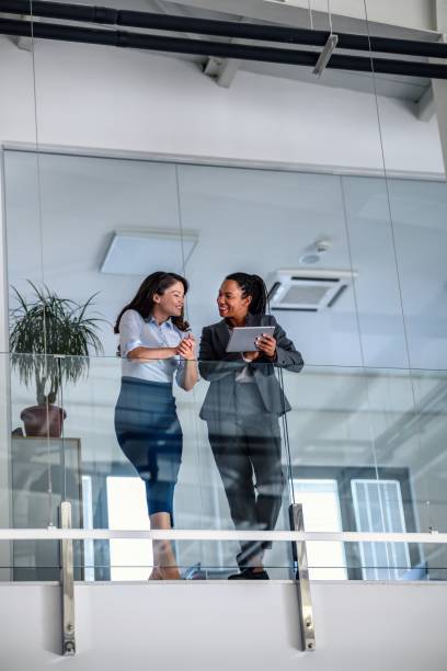 istock Business people leaning against a glass fence and using a digital tablet 2017312489