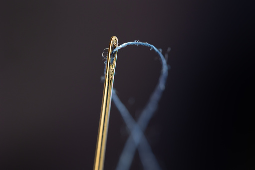 thread threaded into a sewing needle