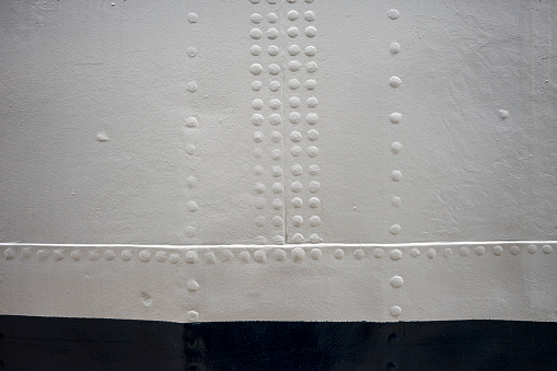 plate metal on board, plates joined with rivets