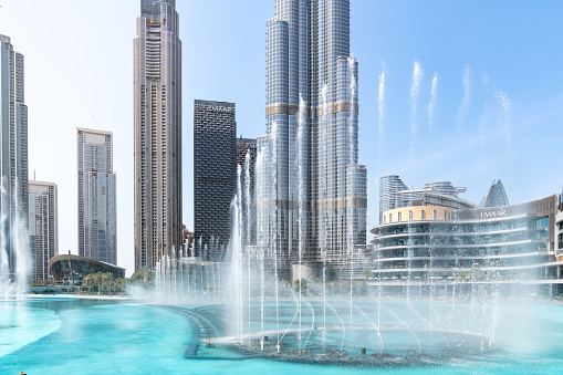 Dubai, United Arab Emirates - March 14, 2023:View of The Dubai Fountain and the big skyscraper Burj Khalifa during a sunny day in Dubai