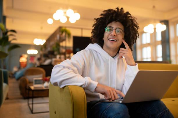 istock Young curly-haired man with laptop working in a hotel hall 2017428493