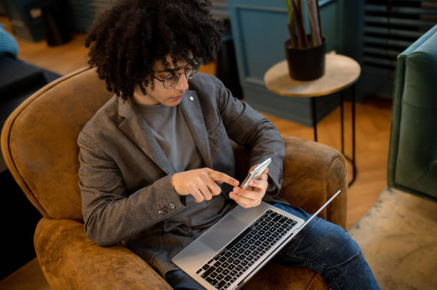 istock Young man with laptop looking contented and smiling 2017428527
