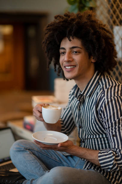istock Smiling young man in striped shirt having coffee 2017429065