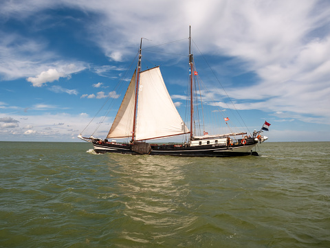 Clipper and brown fleet charter ship sailing on IJsselmeer lake in the Netherlands on a sunny summer day