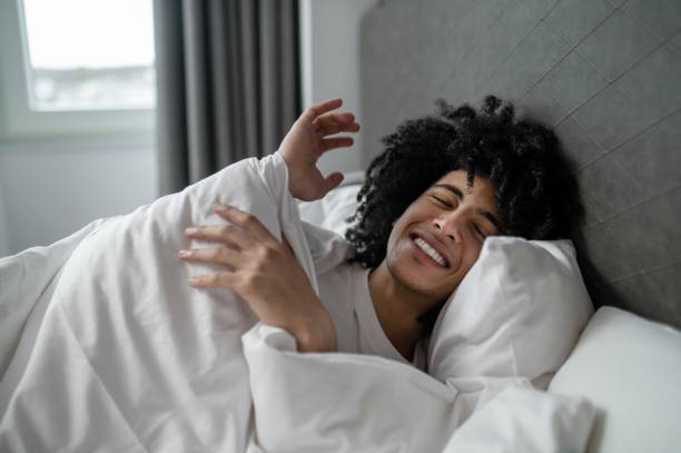 istock Young brunette man lying in bed and looking sleepy 2017429651