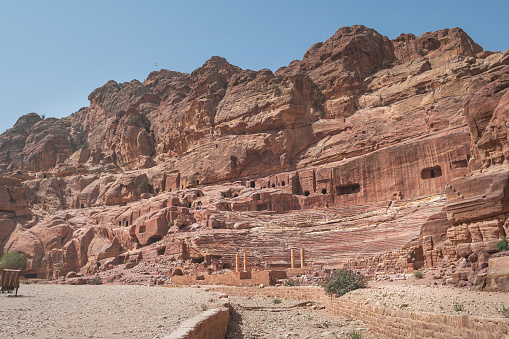 Petra, a renowned archaeological site in Jordan's southwestern desert, dates back to around 300 B.C., serving as the capital of the Nabatean Kingdom, showcasing stunning rock-cut architecture and rich history. Breathtaking rocky terrain of with remaining of ancient objects, surrounded by the vast expanse of the desert sky and the stunning geology of the wadi Makhtesh