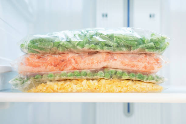 istock Frozen vegetables in a plastic bags in freezer close-up, front view. 2017502834