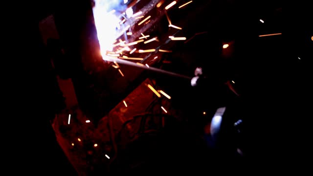 HD Video : Metal worker repairing iron gate with welding machine at night.