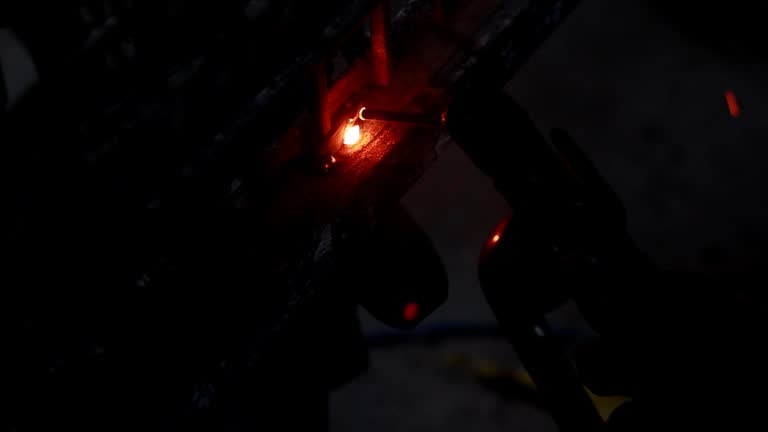 HD Video : Metal worker repairing iron gate with welding machine at night.