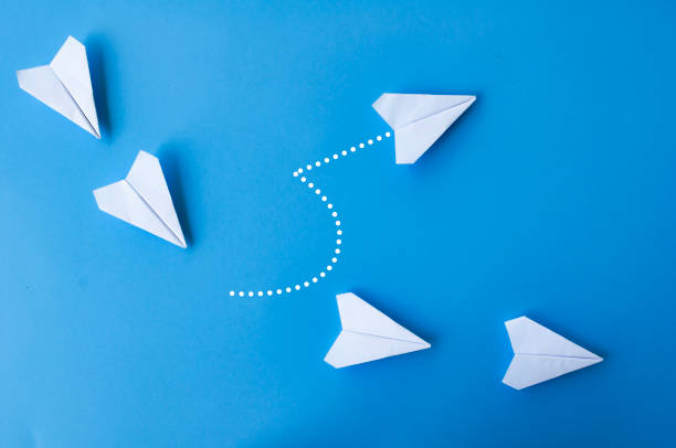 istock Top view of white paper airplanes origami with one flying at different direction. 2017507018