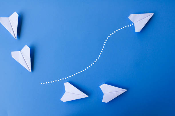 istock Top view of white paper airplanes with one flying at different direction. 2017507532