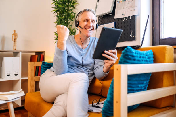 istock Mature man working home office holding digital tablet in hands 2017529303