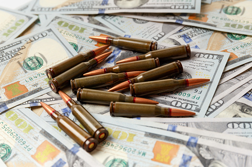 Combat army bullets, cartridges lie on American dollar banknotes, the concept of arms trade, financing of military operations, military aid.