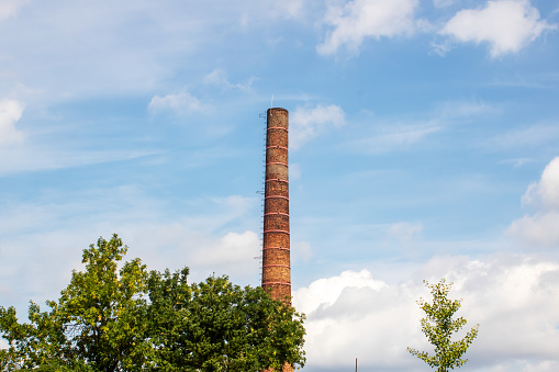 Brick chimney of the factory on the background of the blue sky