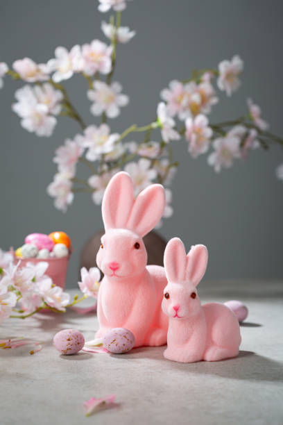 istock Two pink Easter bunny decor and some chocolate eggs pink flowers 2017557197