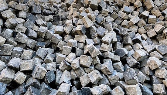A pile of cobblestones in a disorderly arrangement, typically used for paving streets, symbolizing urban construction or repair work