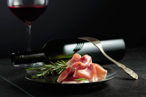 istock Prosciutto with rosemary and red wine on a black background. 2017581397