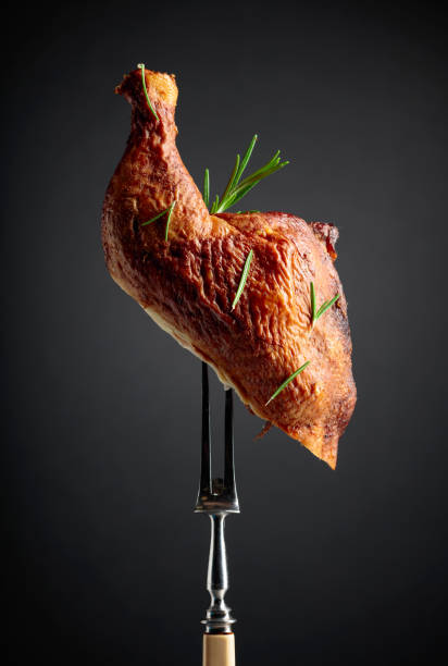 istock Smoked chicken thigh on a fork sprinkled with rosemary. 2017581402