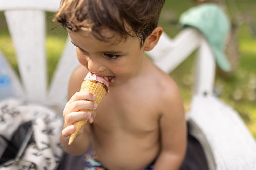 Cute little boy eating sweet ice cream.