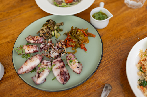 Cloe up of a fried Oegopsida on a plate on wooden table.