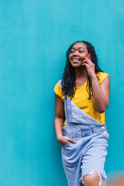 istock Cheerful Afro-Latina Woman Talking on Phone, Turquoise Backdrop 2017619220