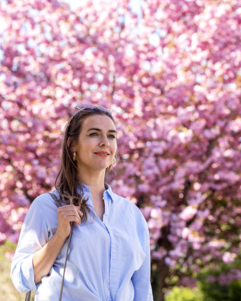 ritratto bella donna nel parco durante la fioritura di sakura rosa. primo piano - focus on foreground joy happiness pink foto e immagini stock