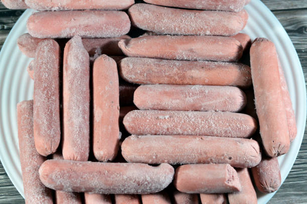 Frozen hot dog, dish consisting of a grilled, steamed, or boiled sausage served in the slit of a partially sliced bun, hotdog is a beef sausage, called wiener (Vienna sausage) and frankfurter frank, selective focus perrito caliente congelado, plato que consiste en una salchicha a la parrilla, al vapor o hervida servida en la hendidura de un panecillo parcialmente cortado, el perrito caliente es una salchicha de res, llamada salchicha (salchicha de viena) y salchicha