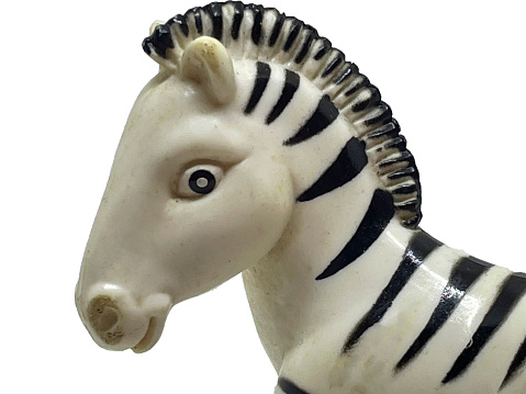 Head of a toy white-black zebra on a white background. Toy animal head of black and white zebra