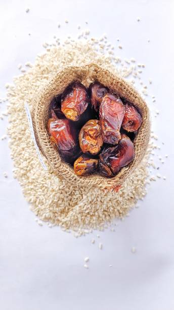 des dattes dans un sac en toile de jute et des grains de riz comme moyen de payer la zakat - dried fruit variation healthy eating snack photos et images de collection