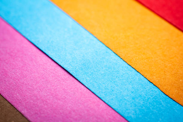 Extreme macro of multicolor background from different colors papers. Abstract colorful vibrant paper textures. Selective focus, shallow depth of field.