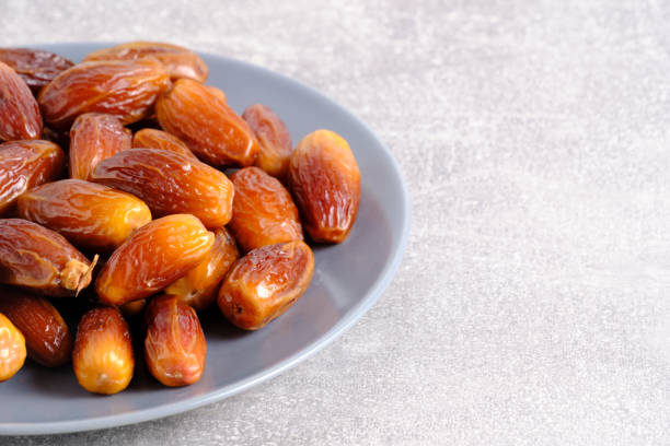 istock Dates plate gray background.Edible fruits date palm. 2017754439
