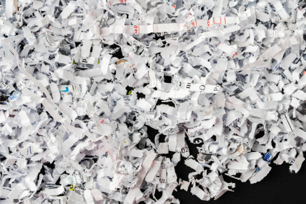 istock Shredded white paper on black background close up 2017763813