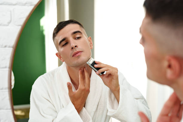 istock Reflection of a young man shaving in bathroom mirror close up 2017764319