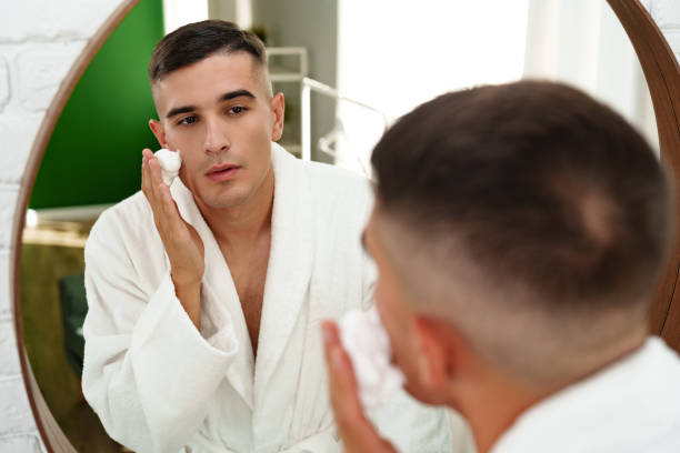 istock Reflection of a young man shaving in bathroom mirror close up 2017764337