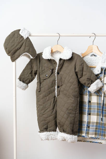 istock Two kids winter coats hanging on hangers against white wall 2017764404