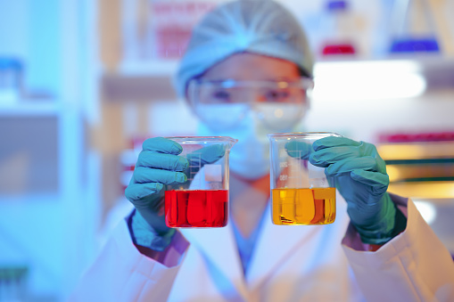 Asian female scientist passionately conducts experiments in a laboratory, surrounded by petri dishes and beakers. Delve into the chemistry of gasoline, food ingredients, and perfumes