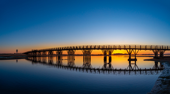 Isla Cristina bridge Pasarela de la Gola at sunset in Huelva of Andalusia in Spain to reach the Playa de la Gaviota beach