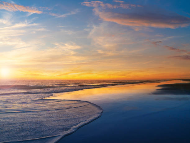 istock Beautiful sunset on the beach with golden and blue sky reflection 2017819307