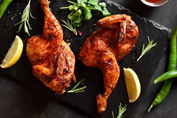 istock Grilled half chicken on black slate plate over dark stone background 2017822514