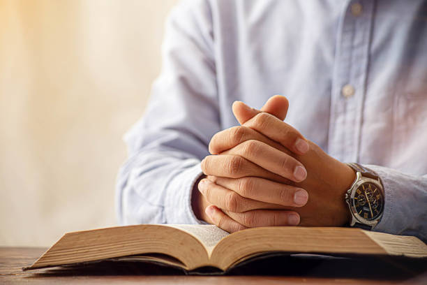 istock Christian man hand praying to god with the bible. 2017830861